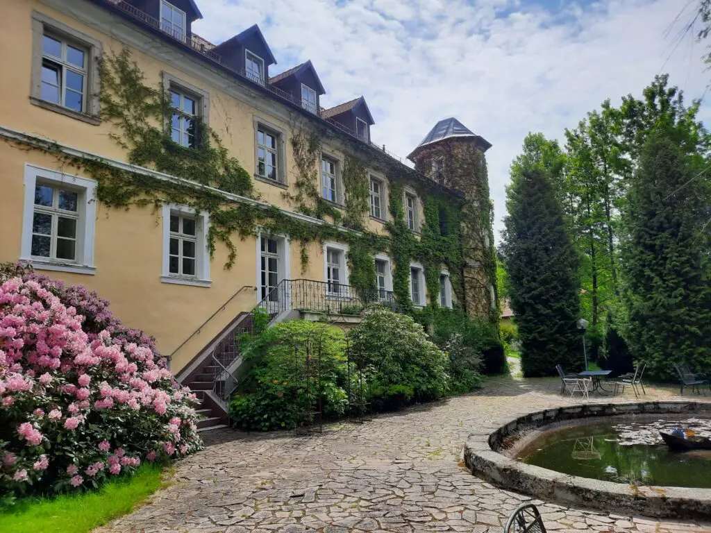 Außenansicht der efeubewachsenen Fassade des Schlosses mit einer kleinen Treppe.