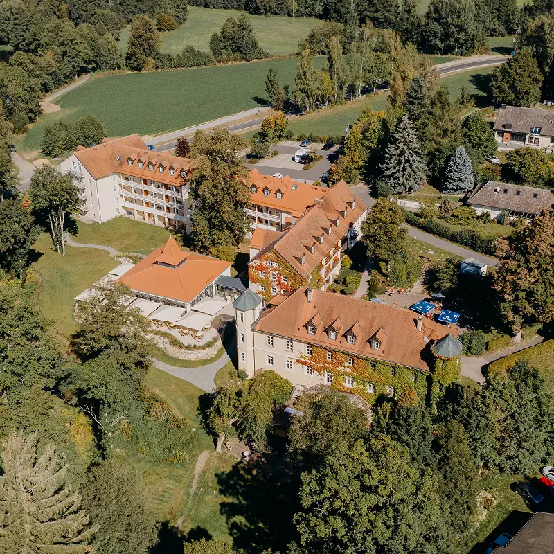 Luftaufnahme des weitläufigen Hotelgeländes, das eingebettet in die Natur liegt.